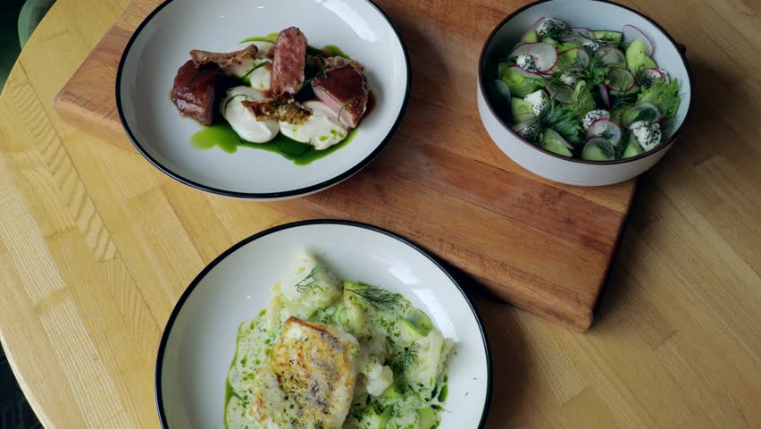 Ready meals, meat, fish and vegetable salad on the table, specialties from the restaurant, three plates with appetizing food, close-up | Shutterstock HD Video #1108760023
