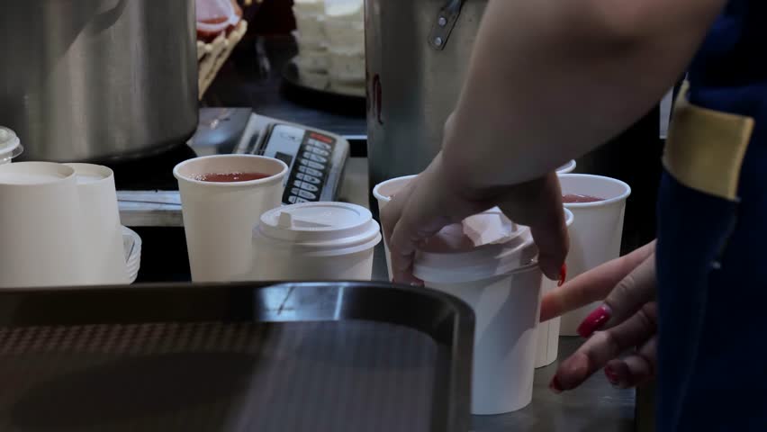 The chef pours drinks into paper cups, the drink is poured into disposable glasses, cool drink, charity kitchen, drink preparation. | Shutterstock HD Video #1108760035