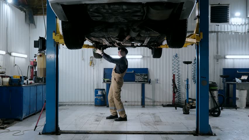 A male auto mechanic inspects a car, auto diagnostics in a car service. Car maintenance | Shutterstock HD Video #1108760039