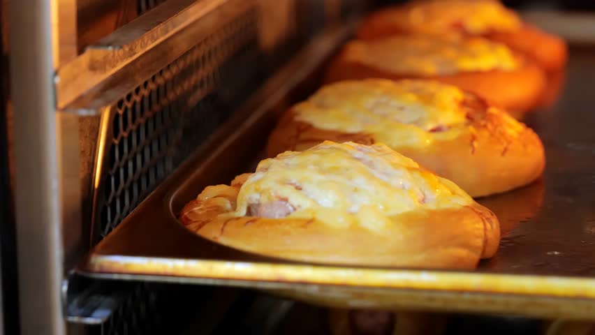 Ready-made pastries in the oven, sausages in the dough and buns with minced meat in the oven. | Shutterstock HD Video #1108760051