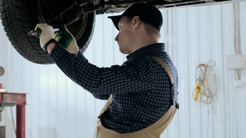 Auto mechanic inspects car suspension, car suspension diagnostics. Male mechanic inspecting a car | Shutterstock HD Video #1108760073