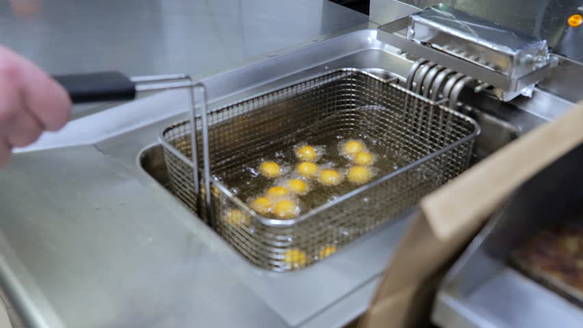 Top view cheese balls are being fried in the boiling oil. Oil is boiling over electric fryer.Food concept. | Shutterstock HD Video #1108760125