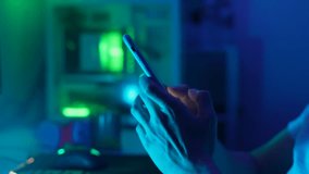 Close-up of unrecognizable stressed man scrolling internet website on mobile phone, reading bad news sms, fraud notification, having problem using smartphone apps on dark room with neon bokeh lights. - Powered by Shutterstock - Get 15% off with code: PIKWIZARD15