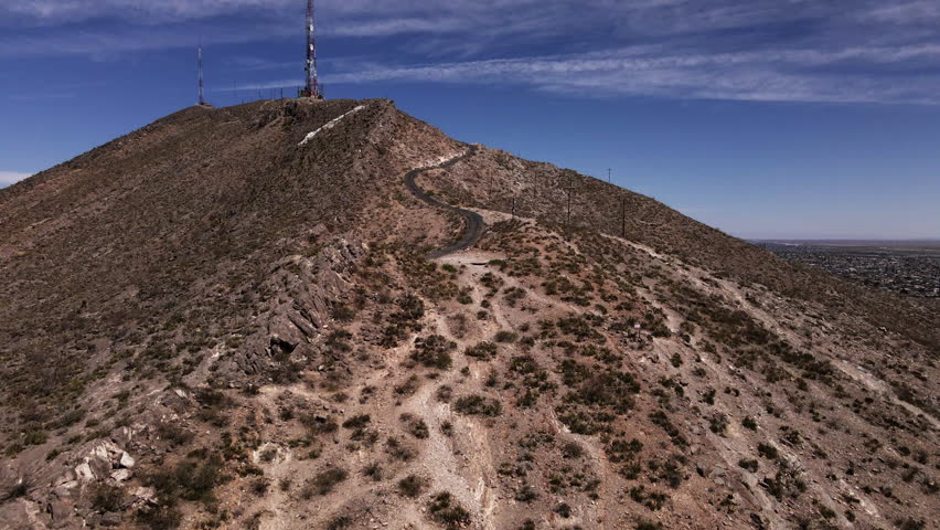 Aerial dolly-in towards radio towers on top of mountain near El Paso, TX
