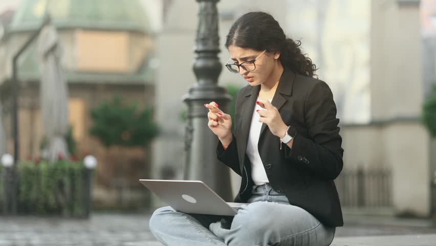Pretty young woman freelancer with crossed fingers wait for news celebrate exam result online win success reading great news feel amazed happy reading message email on laptop at city Triumph concept Royalty-Free Stock Footage #1108766987