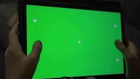 Close up shot of hands of man holding a tablet computer with green chroma key screen. Guy watching a video or having an online chat in cafe always online 4k template footage - Powered by Shutterstock - Get 15% off with code: PIKWIZARD15