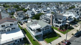 American flag waving on beach house. Aerial descending shot of high end neighborhood in beach town. - Powered by Shutterstock - Get 15% off with code: PIKWIZARD15