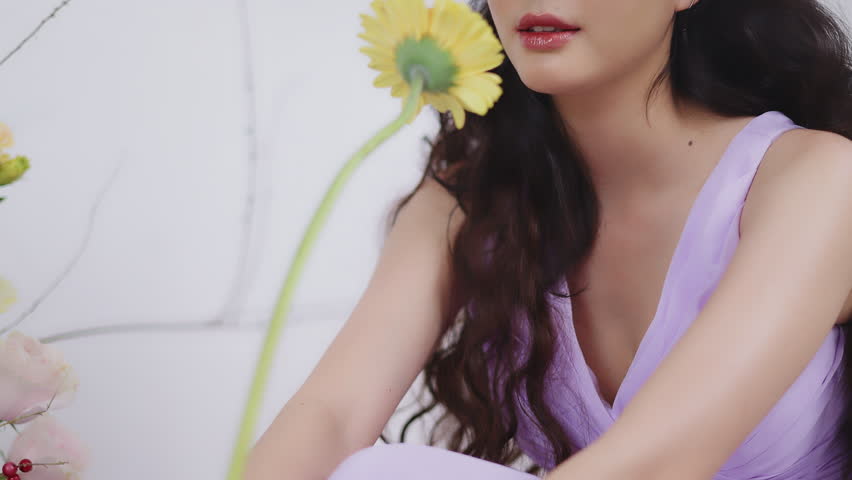 Sensual young beauty Asian woman among flower bouquets.