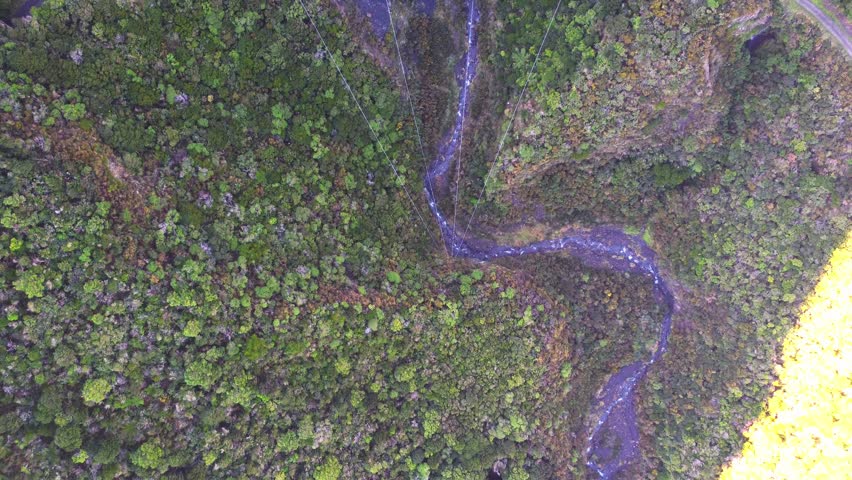 Birdseye view, flying over a large suspension bridge with a river underneath. Siberia Gully, Remutaka cycle trail, New Zealand.
