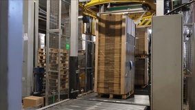 Industrial equipment - typical stretch wrapping machine in process of work. Packaging of corrugated cardboard. Selective focus. - Powered by Shutterstock - Get 15% off with code: PIKWIZARD15