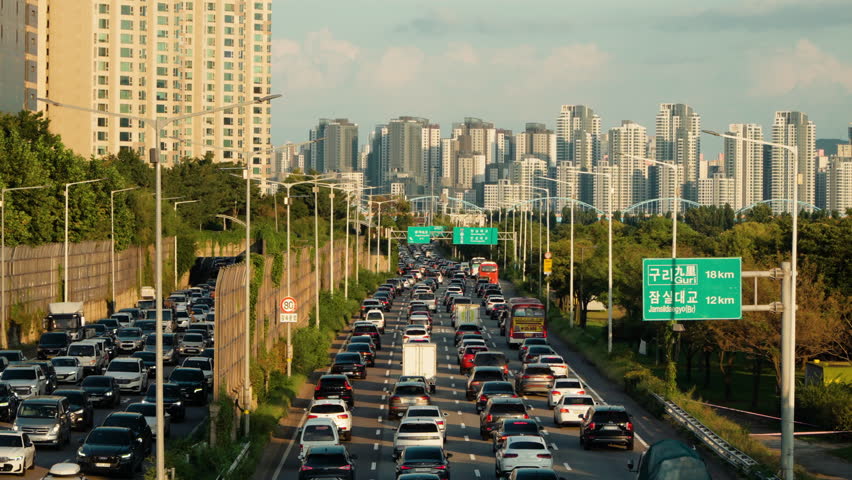 Commuters Stuck in Slow Moving Traffic After Work During Rush Hour in Seoul, South Korea. Gangbyeonbuk-ro Expressway in Summer on Sunset Royalty-Free Stock Footage #1108778041