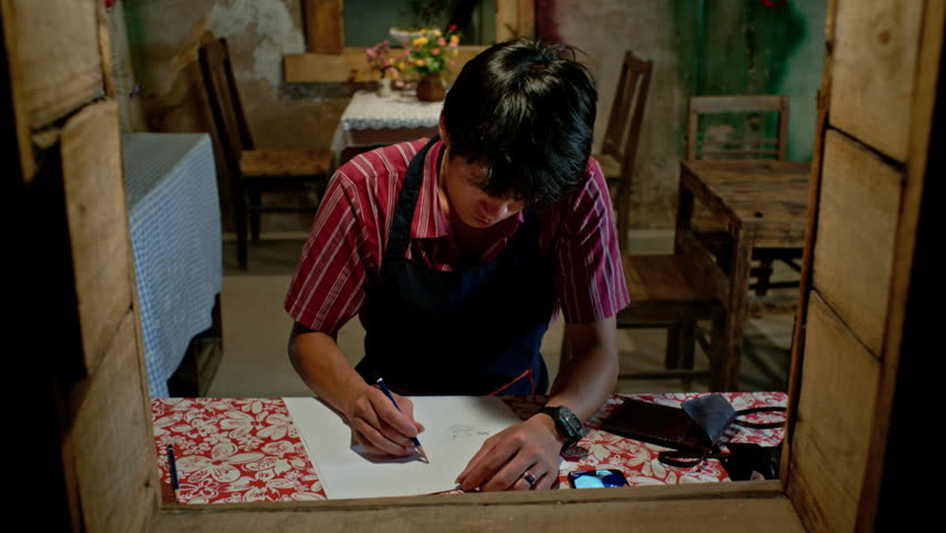 artist drawing on paper at the window, static