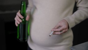 Careless pregnant woman with cigarette and beer bottle dancing indoors. Young unrecognizable Caucasian expectant with tobacco and alcohol at home - Powered by Shutterstock - Get 15% off with code: PIKWIZARD15