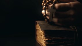 Hands folded in prayer on a Holy Bible in church. Woman praying with a wooden cross. Spirituality religion and hope concept. Supplication believe and faith. Abstract vintage religious dark background - Powered by Shutterstock - Get 15% off with code: PIKWIZARD15