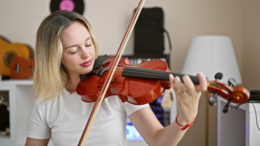 Young blonde woman musician playing violin at music studio Royalty-Free Stock Footage #1108783879