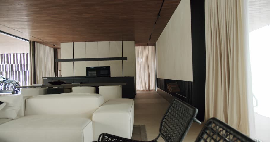 Stylish house with minimalist interior design and modern furniture, comfortable couch, dining table, kitchen cabinet, household appliances and panoramic windows or glass wall