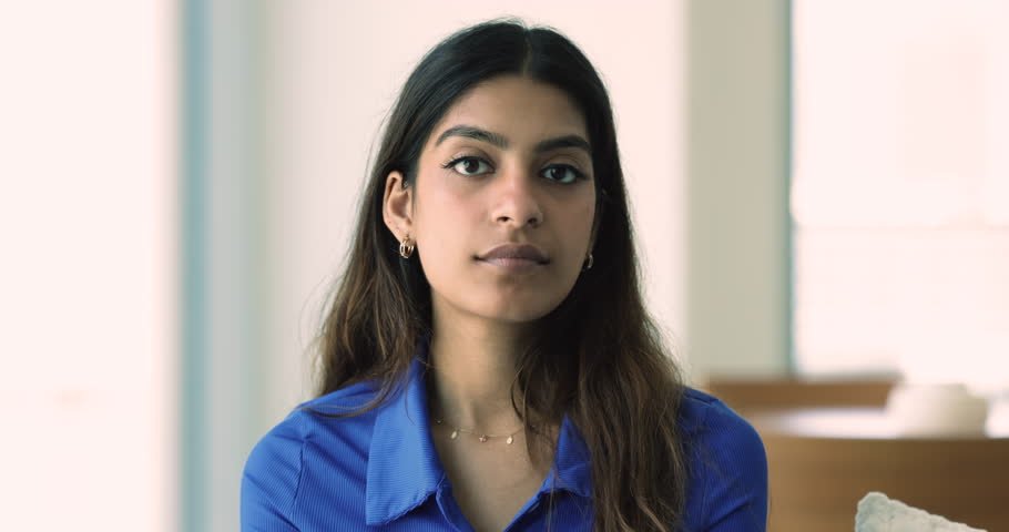 Head shot of beautiful young Indian woman in casual clothes posing standing alone indoors, having pretty appearance and wide toothy candid smile. Portrait of millennial generation good-tempered person Royalty-Free Stock Footage #1108798103