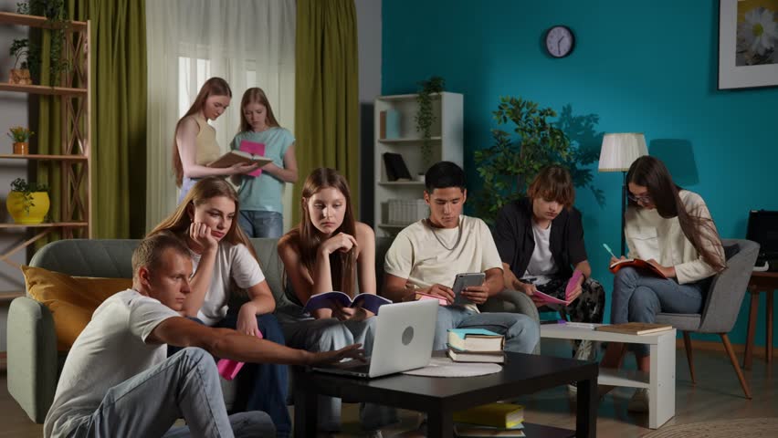 Full-size video of a group of teens, young people, friends studying, preparing for an exam, discussing, looking at their notes, using devices, watching something.