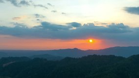 aerial hyper lapse view The red sun slowly rises over the top of the mountain. 
beautiful sky in sunset cloud over the mountain. red sun going down to mountain ridge.
beautiful nature background.4k 