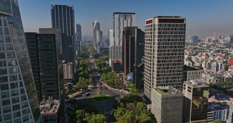 Mexico City Aerial v45 low level flyover wide avenue paseo de la reforma between urban and modern high rise buildings capturing established downtown cityscape - Shot with Mavic 3 Cine - December 2021 Royalty-Free Stock Footage #1108807891
