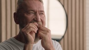 Close up Caucasian old male retired middle-aged senior mature elderly man brushing teeth with dental floss care tooth wellness morning hygiene procedure oral anti cavity dental procedure dentistry - Powered by Shutterstock - Get 15% off with code: PIKWIZARD15