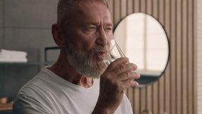 Old Caucasian man middle-aged senior mature male ill sick bad feeling pensioner at home drinking pill remedy dose medicine drug vitamin painkiller medical supplement drink water smiling at camera - Powered by Shutterstock - Get 15% off with code: PIKWIZARD15