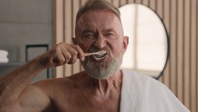 Close up old male retired middle-aged senior mature elderly man brushing teeth with toothbrush and toothpaste enjoying morning oral anti cavity hygienic routine in bathroom tooth care dental hygiene - Powered by Shutterstock - Get 15% off with code: PIKWIZARD15