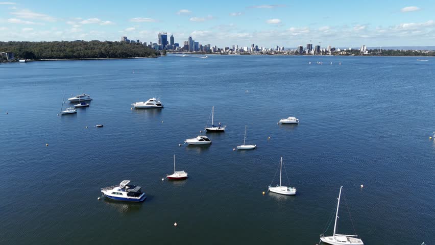 Cinematic aerial view of Perth city skyline in Western Australia with sailing yachts moored in Matilda Bay marina