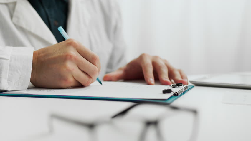Patient. A male doctor in doctor's clothes works competently at a table in the waiting room. Close-up of a clinic worker specialist writing data information advanced diagnostic methods, medical care Royalty-Free Stock Footage #1108815361
