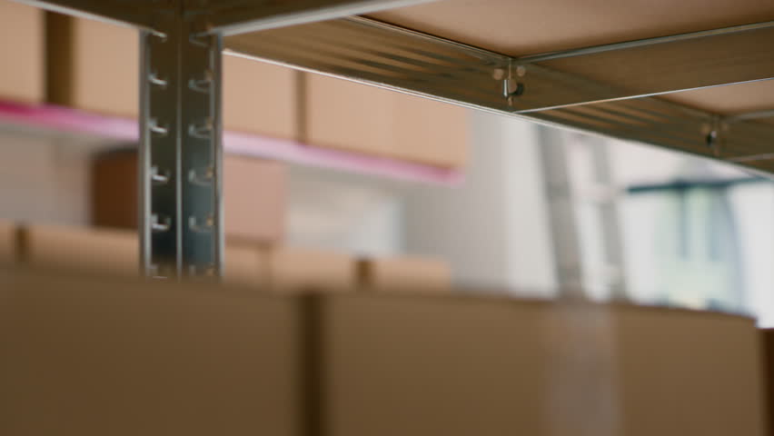 Quality assurance manager and warehouse laborer preparing orders for delivery, using digital device to check shipping info while scanning labels on parcels in retail deposit