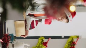 Vertical video Petty worker packs desk belongings and steals Christmas office decoration on last day at work. Woman getting fired from job during year end layoffs before xmas holiday, taking revenge - Powered by Shutterstock - Get 15% off with code: PIKWIZARD15