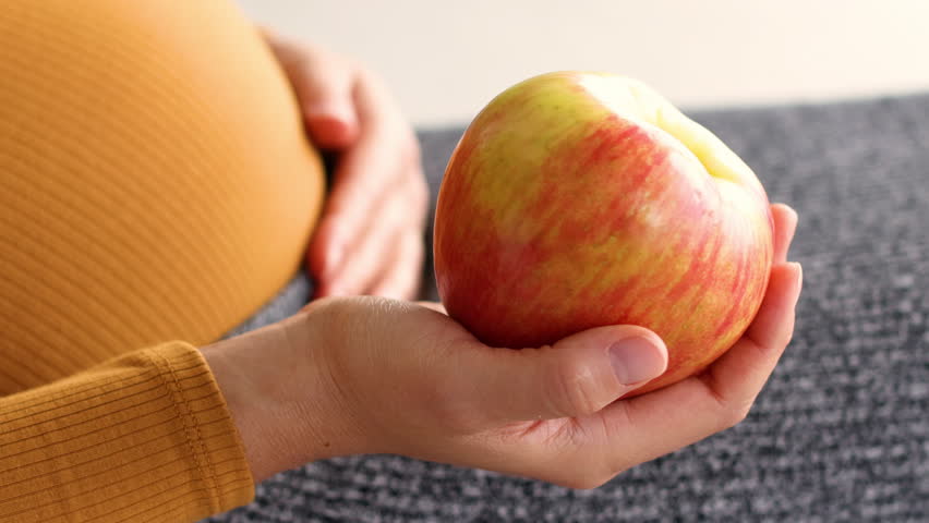 Pregnancy healthy eating pregnant woman vegan diet holding apple for breakfast or lunch snack. Fruit craving during second trimester. Royalty-Free Stock Footage #1108823555