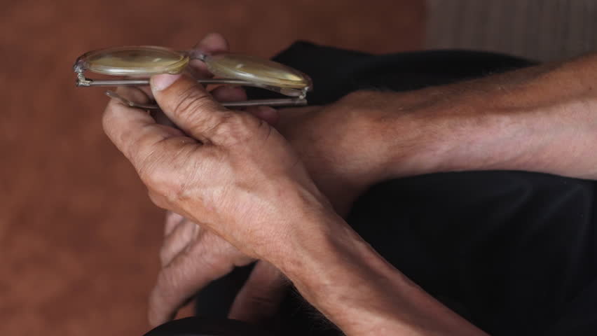 Vintage glasses in the hands of an old man. concept of elderly people wearing glasses. deterioration of vision in old age. real elderly people. age 70 -79 years | Shutterstock HD Video #1108829727
