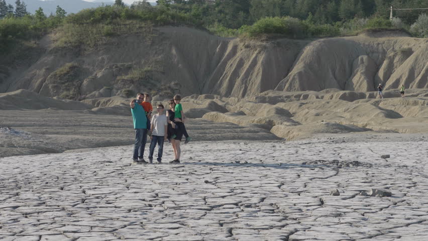Big family selfie in the arid desert landscape of mud volcanoes, Romania