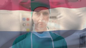 Animation of waving netherlands flag over caucasian female surgeon wearing surgical mask at hospital. Medical healthcare and patriotism concept - Powered by Shutterstock - Get 15% off with code: PIKWIZARD15
