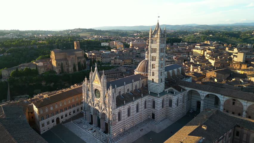 Siena Cathedral or Duomo di Siena, a medieval church in Siena, Italy. Drone orbit shot at sunset
