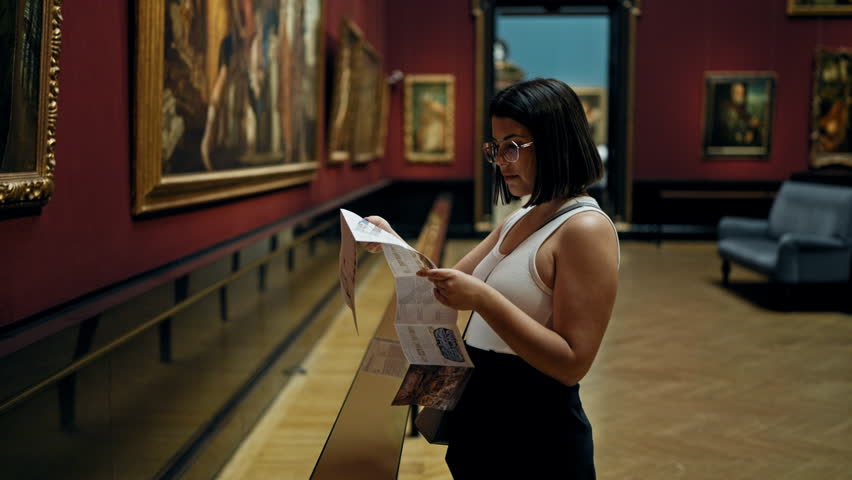 Young beautiful hispanic woman visiting art gallery reading brochure at Art Museum in Vienna Royalty-Free Stock Footage #1108838091