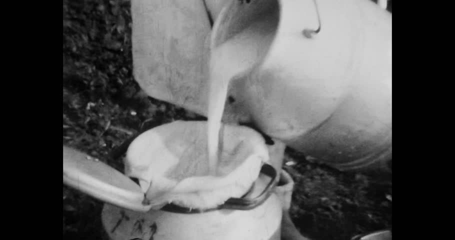 Close-up, milk pouring in can on farm, top view. Cow milk production on industrial, factory farm. Dairy products in countryside farming. 1960s. Vintage black white archival film. Retro archive Royalty-Free Stock Footage #1108838433