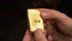 worker checks after casting a homemade gold bar made in artisanal conditions, looking at its texture and reflections with tints - Powered by Shutterstock - Get 15% off with code: PIKWIZARD15