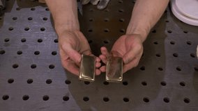 after grinding and polishing, the worker checks after casting a homemade gold bar made in artisanal conditions, looking at its texture and reflections with iridescence - Powered by Shutterstock - Get 15% off with code: PIKWIZARD15