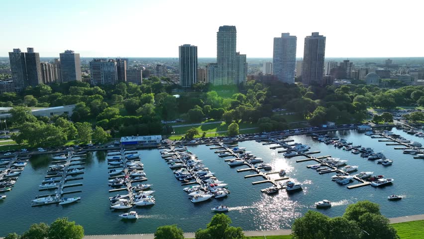 Diversey Harbor in Lincoln Park near downtown Chicago. Aerial establishing shot of luxurious docks on Lake Michigan on summer day. People taking boats and yachts out on lake.