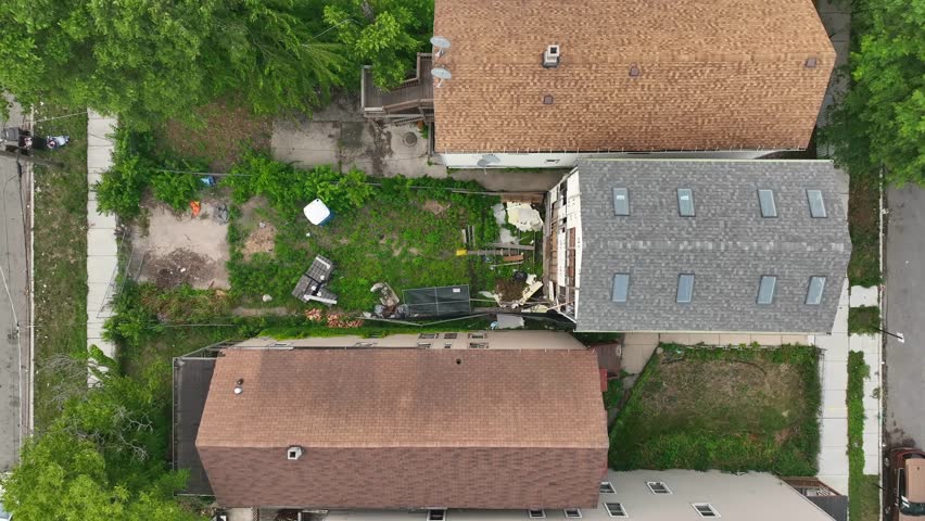 Abandoned and desolate row house in urban city. Aerial descending shot above overgrown yard and home with destroyed windows and walls. | Shutterstock HD Video #1108853403