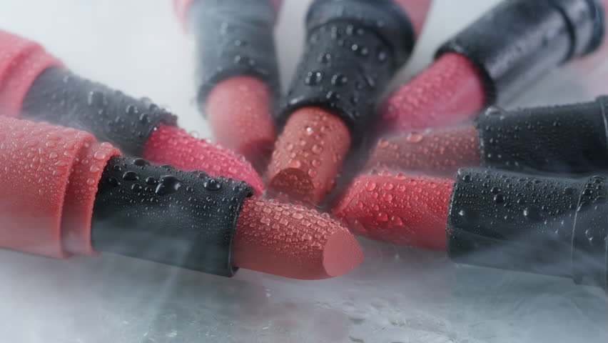 Red lipsticks make up close up background with smoke and water drops, different shades of pink bronze lipstick, studio advertising macro beauty concept. | Shutterstock HD Video #1108853657