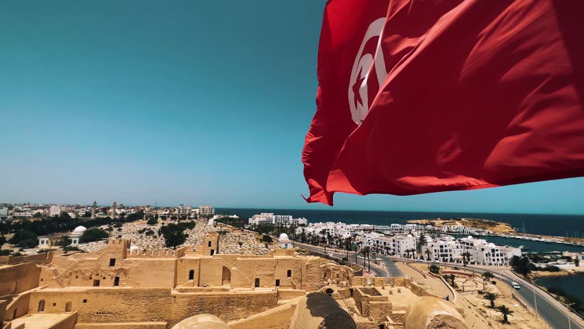 Tunisia flag waving from the Ribat of Monastir fortress with view on the sea and city of Monastir Royalty-Free Stock Footage #1108853813