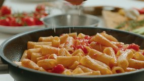 Extreme close-up shot of grating cheese over hot rigatoni pasta with tomato sauce cooked in frying pan - Powered by Shutterstock - Get 15% off with code: PIKWIZARD15