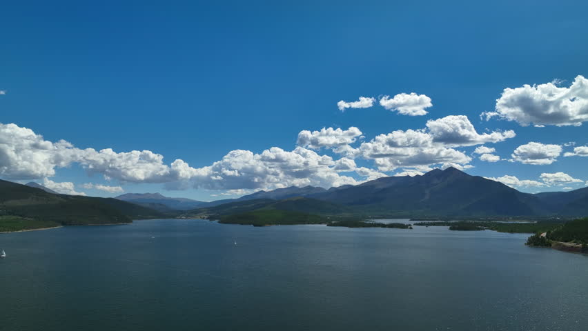 Aerial cinematic drone Breckenridge ski resort mountain wide motorboats sailing Lake Dillon Colorado 9 mile range summer blue sky beautiful daytime Frisco Silverthorne Reservoir circle left motion