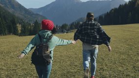 Young people in love hiker couple date dating with backpacks have fun run walk travel in the mountains hiking route, back view, Austrian Alps. trekking, nature, activity, exploration, adventure