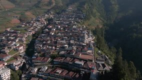 View of countryside on the slope of mountain during sunny day. Drone shot of Nepal van Java on the slope of Sumbing Mountain, Indonesia - 4K aerial view