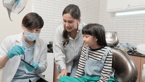 Asian male pediatric dentist explains teeth X-ray scan to girl and her mother for dentistry hygiene from tablet in dental clinic, professional orthodontic oral doctor in a kid healthcare hospital. - Powered by Shutterstock - Get 15% off with code: PIKWIZARD15