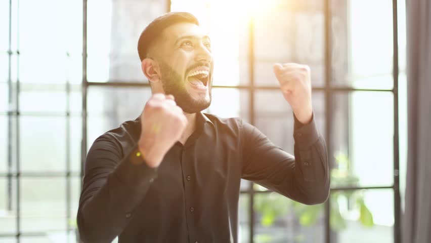 young businessman celebrating success in his home office